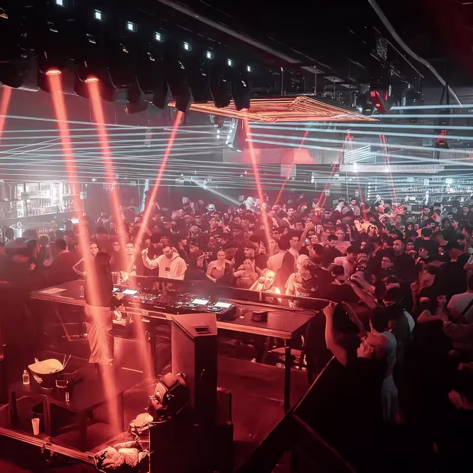 Sala Pandora, una multitud vibrante, luces láser impactantes y un DJ que domina el escenario para crear una noche llena de energía y ritmo.