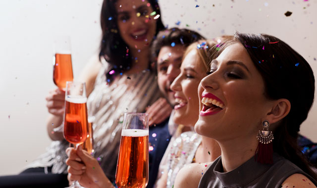 grupo de personas riendo y celebrando con copas de champán