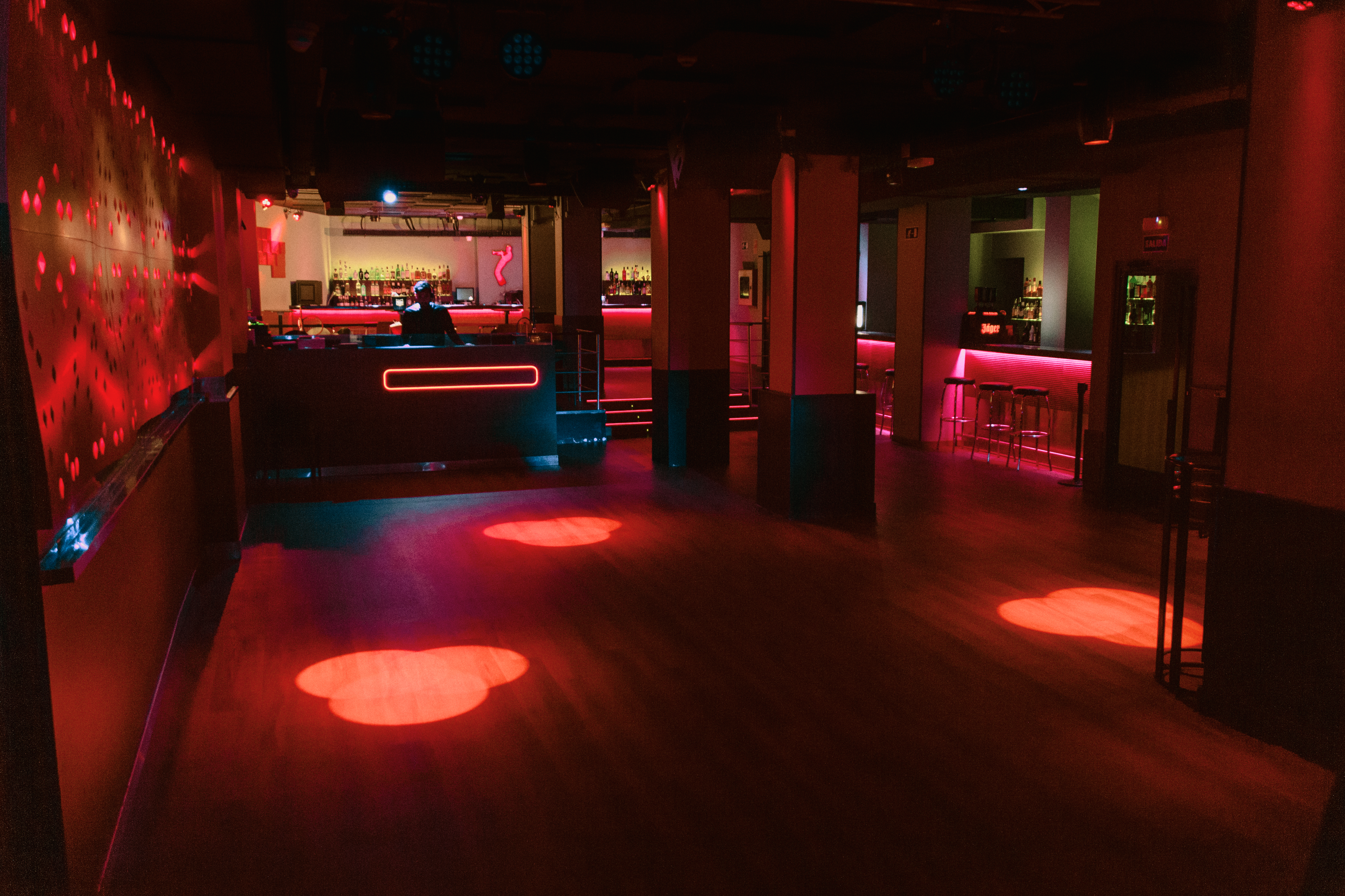Sala Clamores con iluminación vibrante y cabina de DJ, perfecta para disfrutar de conciertos y copas en un ambiente nocturno único en Madrid.