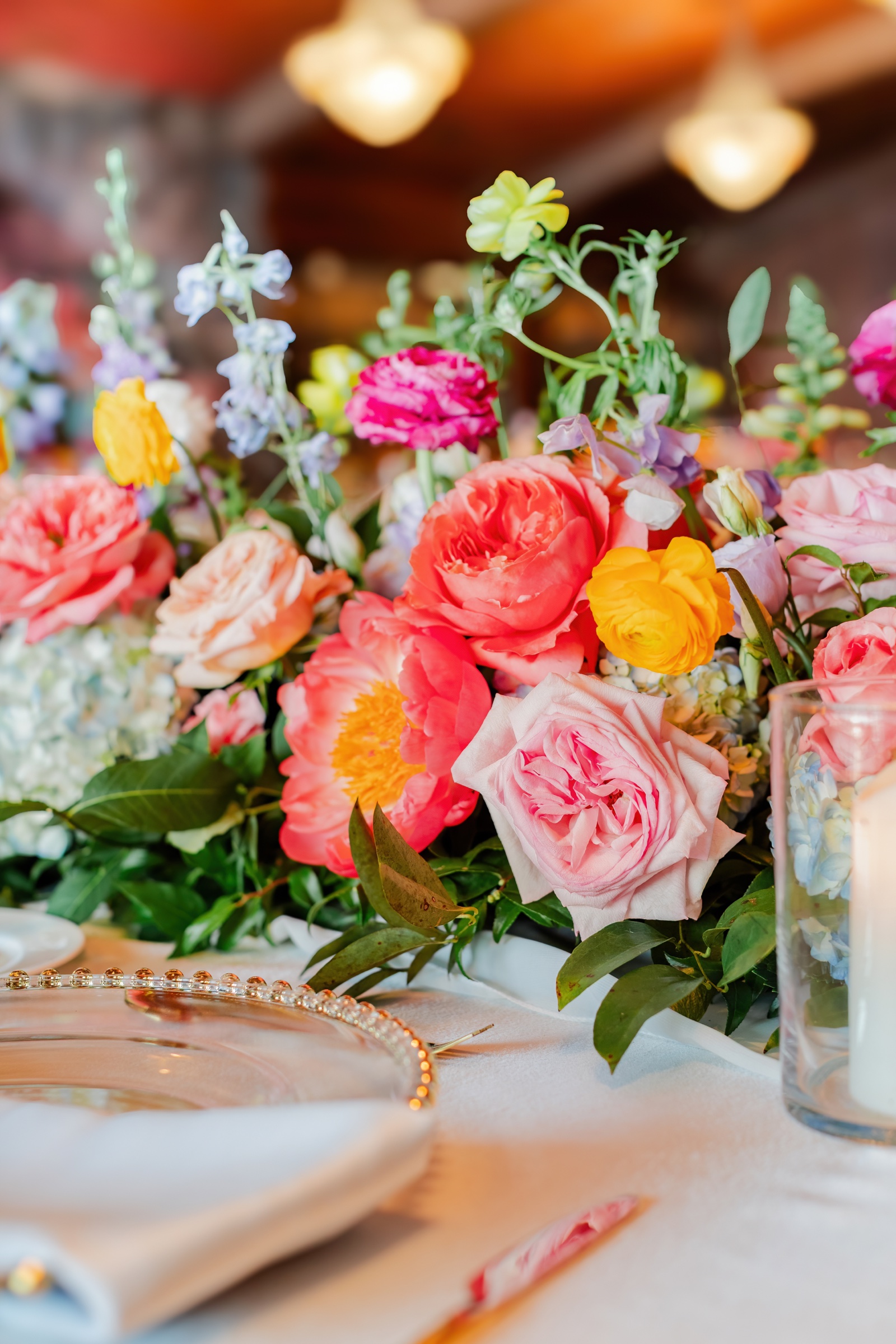 Colorful fall wedding flowers in coral, red, yellow, and blue by He Loves Me Flowers at Big Cedar Lodge in Southwest Missouri
