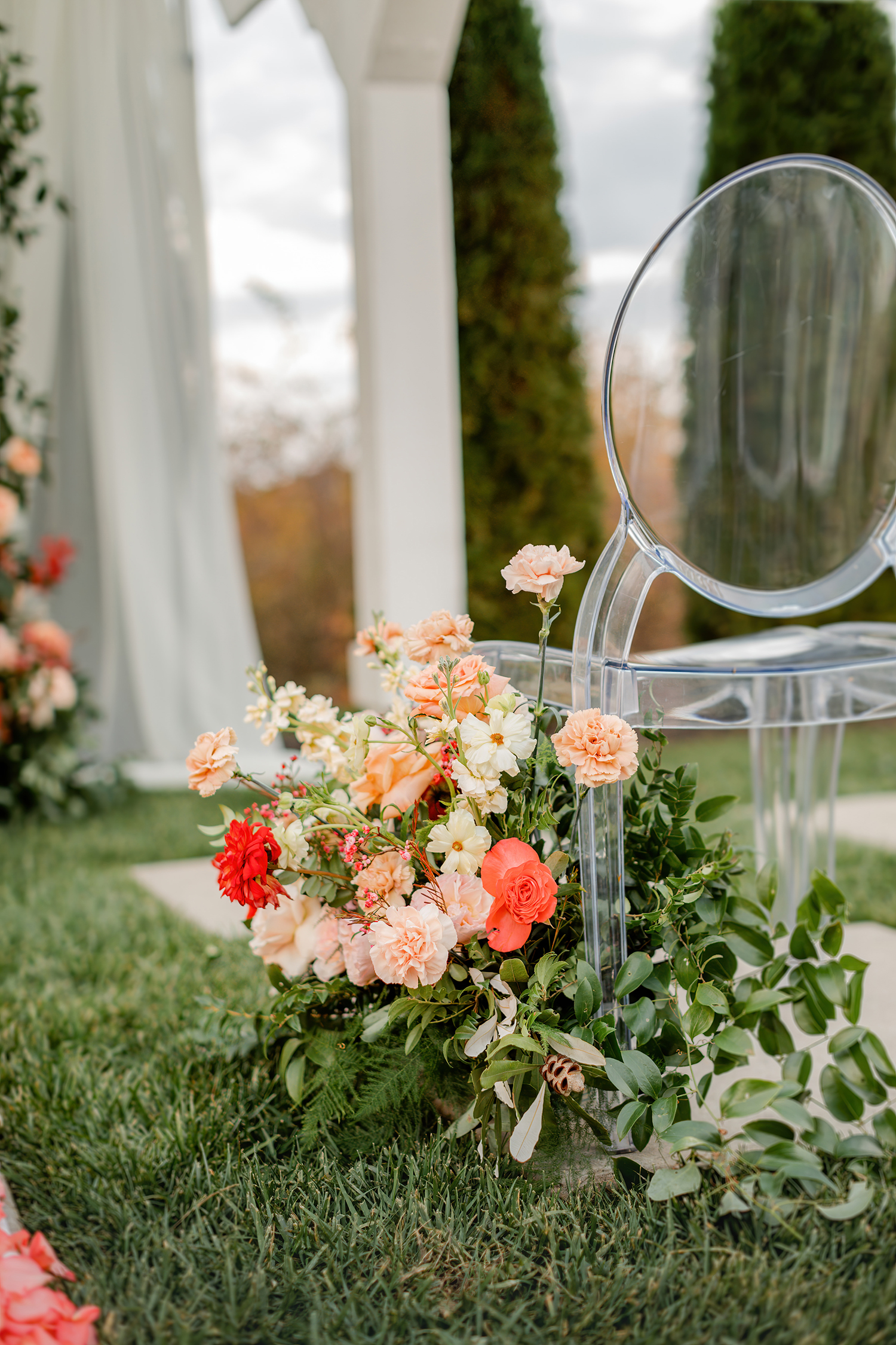 Ground arrangement of peach and coral blooms lining a petal aisle