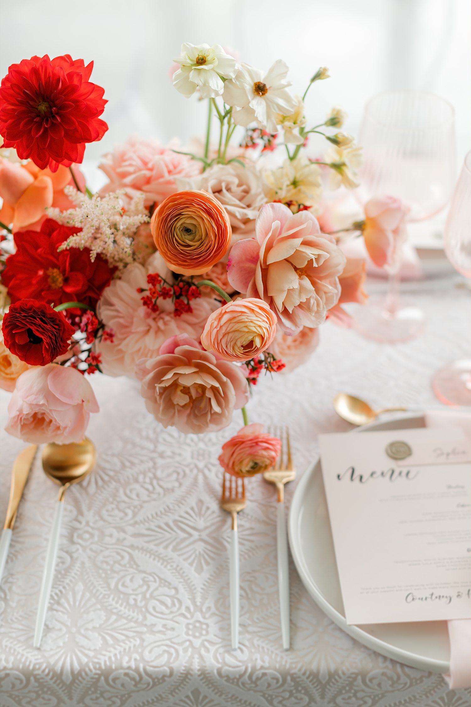 Reception centerpiece with deep red blooms and coral garden roses