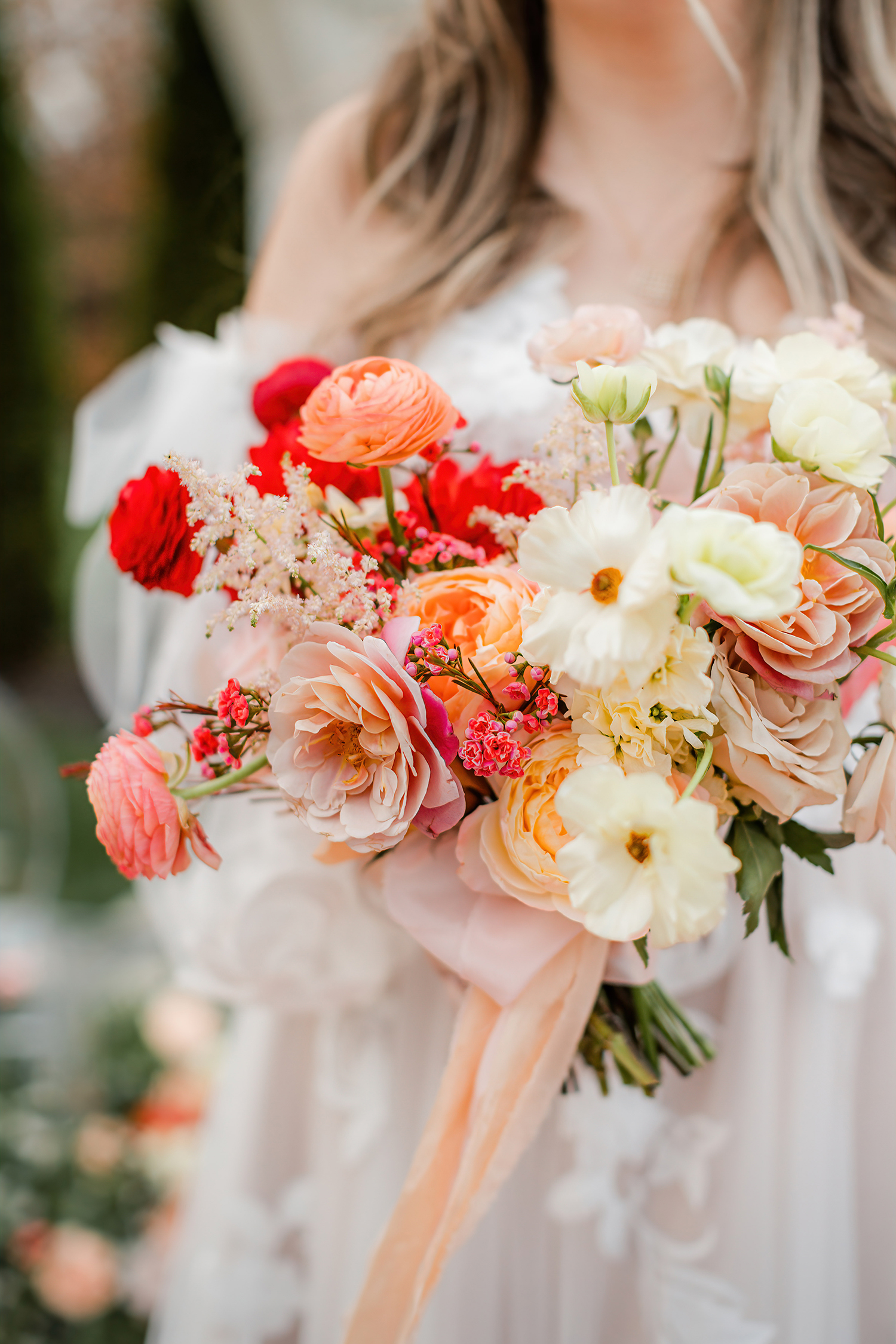 Bouquet of coral, peach, and cream blooms in warm terracotta tones