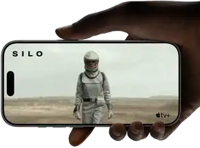 Main tenant un iPhone 17 Pro, argent, orientation paysage, lecture vidéo sur l’écran intégral illustrant l’autonomie