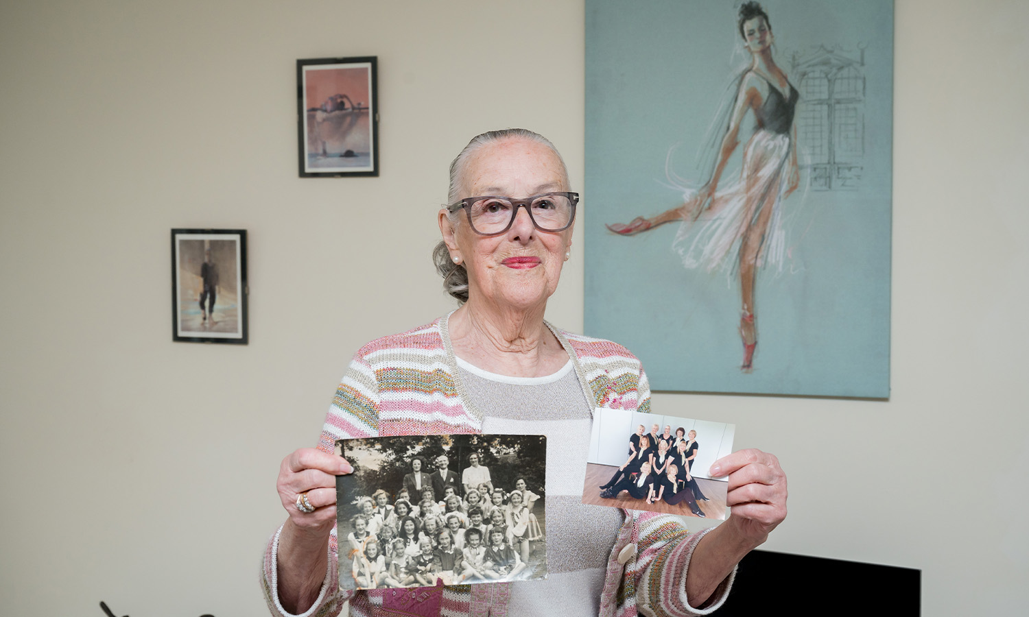 Victoria holds up photos of her dance classes from 1947 and 2022