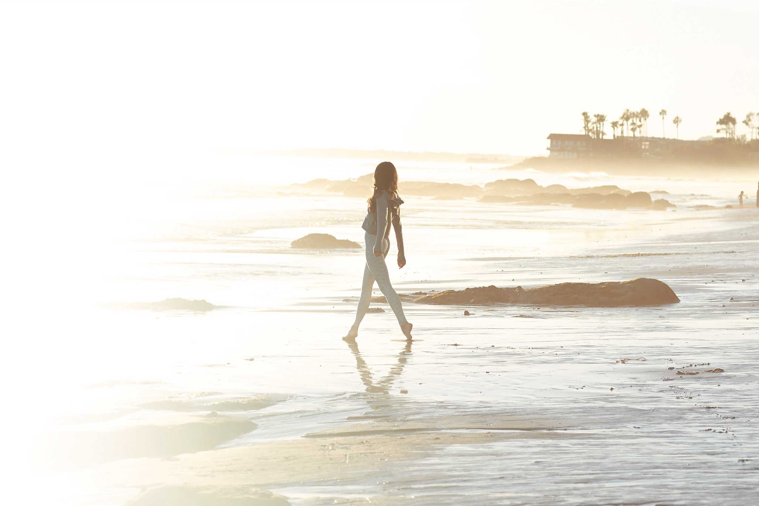 Ethona model walking into a reflective shoreline.