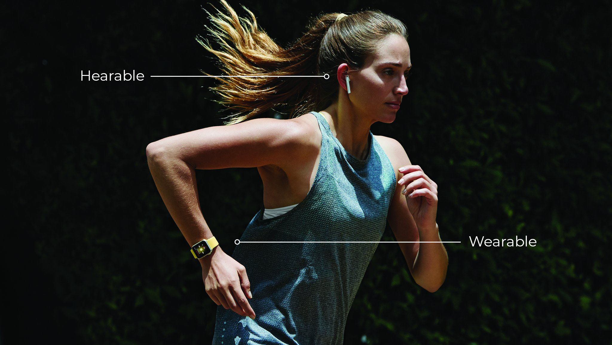 A woman jogs wearing hearables and wearables. 