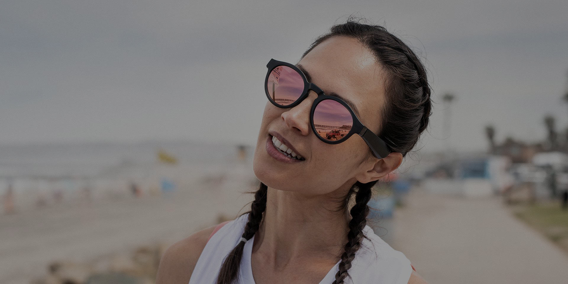 A woman wears Bose Frames Rondo on a sunny beach.
