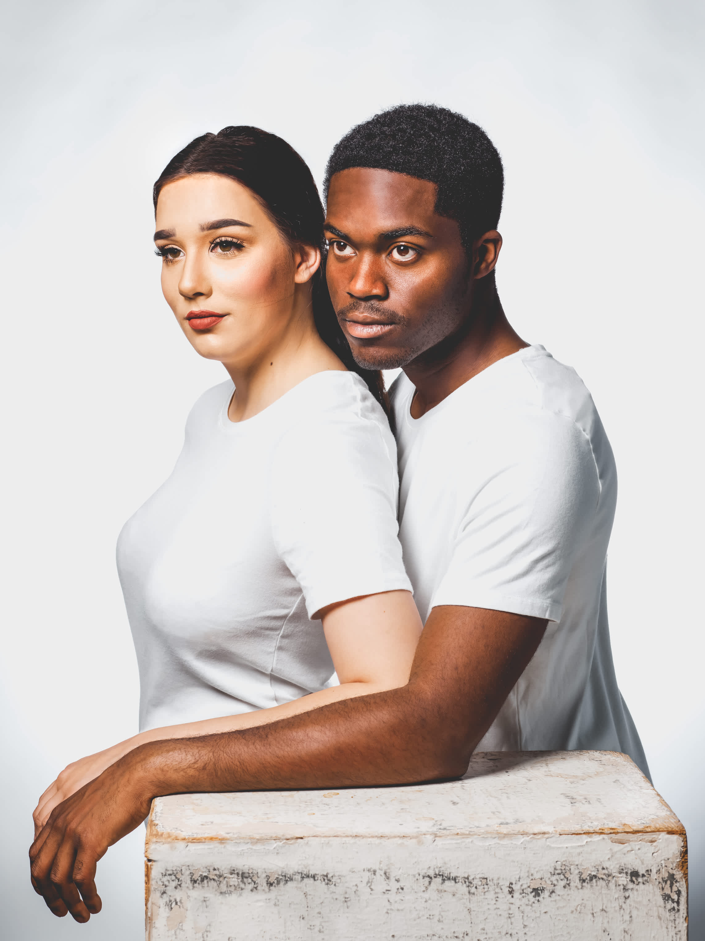A man and woman wearing white t-shirts and standing together.