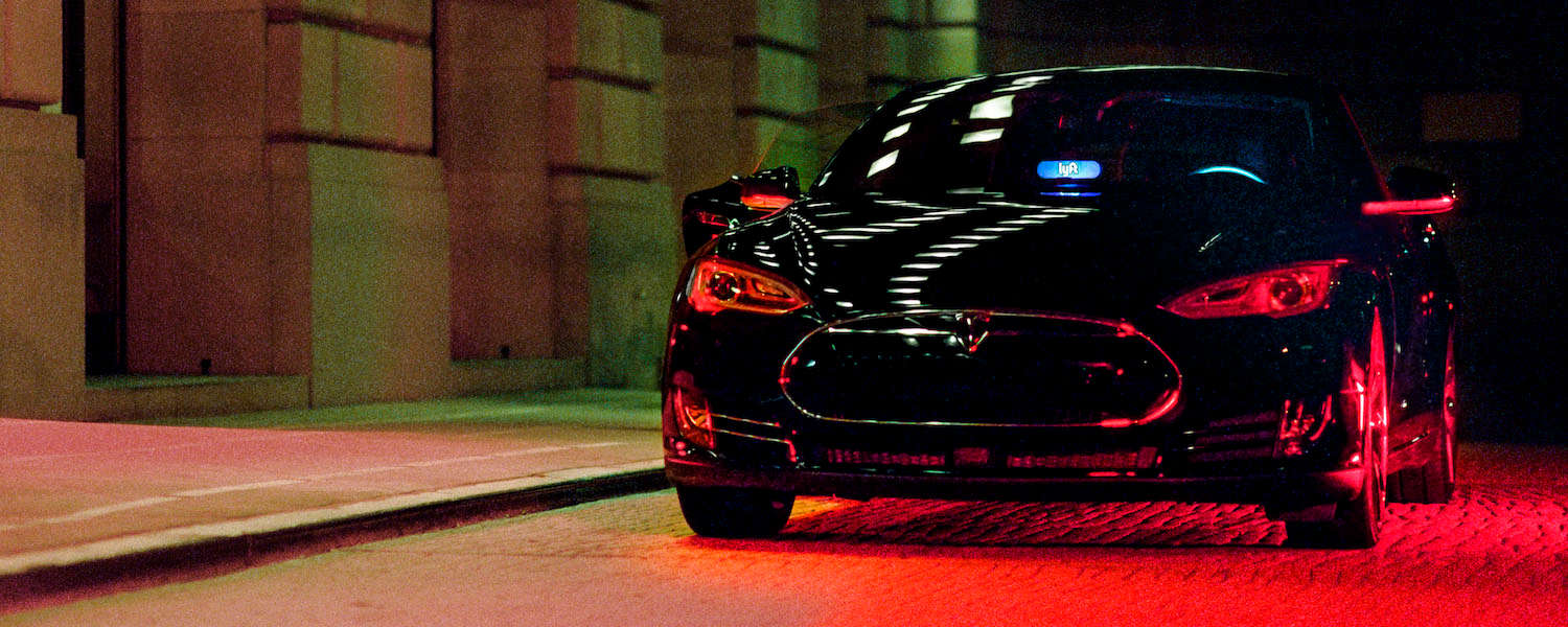 A black Lyft with a blue Amp in the windshield.