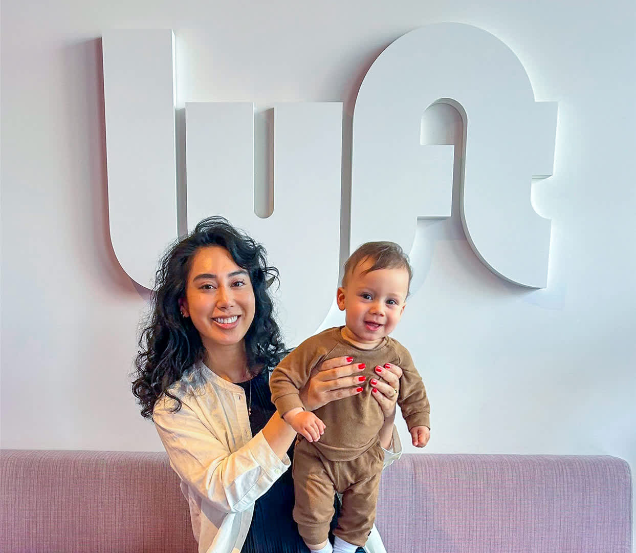 Kharissa holding her baby in front of a Lyft sign