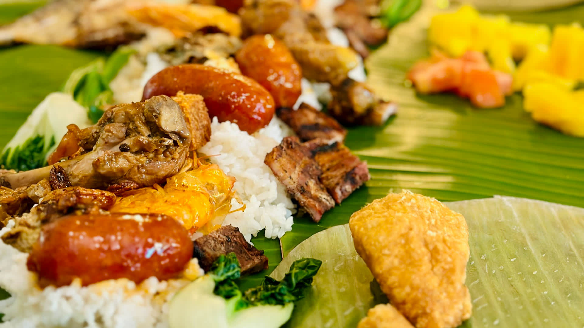 A traditional kamayan feast with Filipino food laid out on banana leaves.