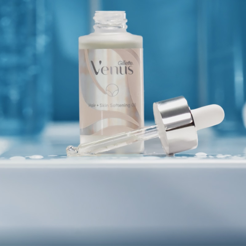 Flacon ouvert d'huile adoucissante pour pour peau et poils pubiens de Gillette Venus