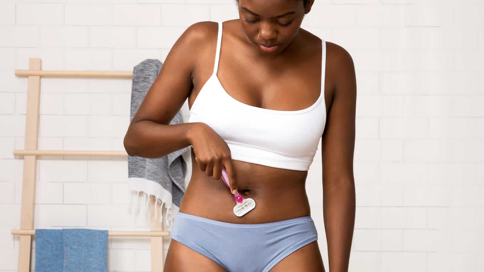 Femme rasant une zone sensible de son ventre avec le rasoir Gillette Venus Femme rasant une zone sensible de son ventre avec le rasoir Gillette Venus
