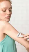 Femme se rasant le bras avec un rasoir argenté