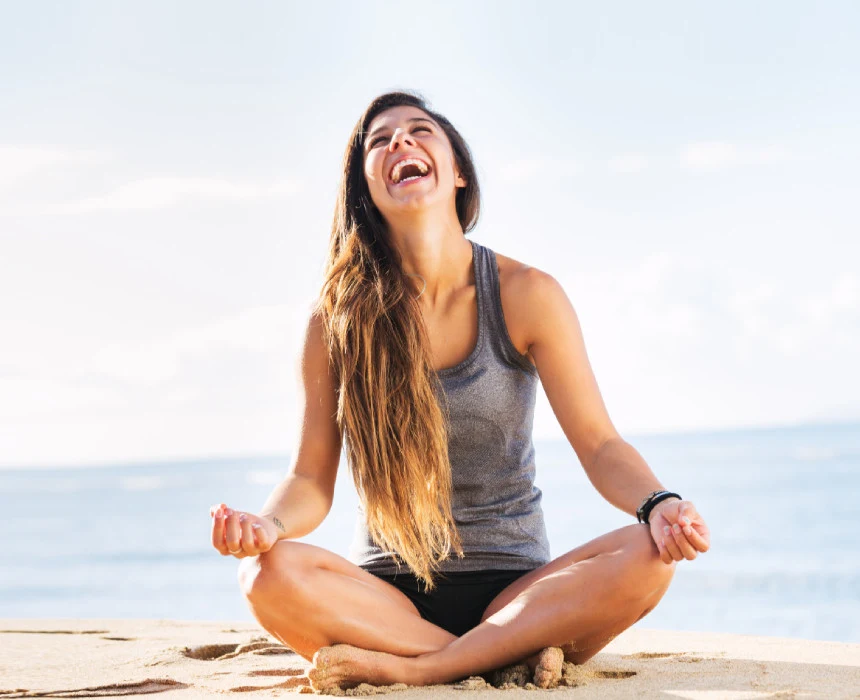 Woman sitting in a meditative pose and smiling