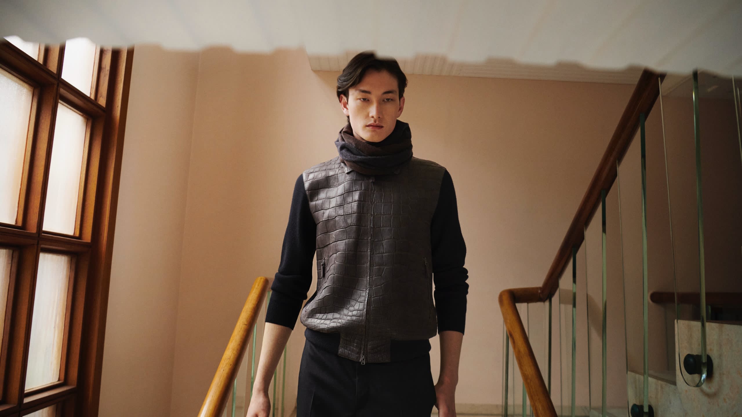 Male model wearing a Brioni leather blouson and brown wool trousers