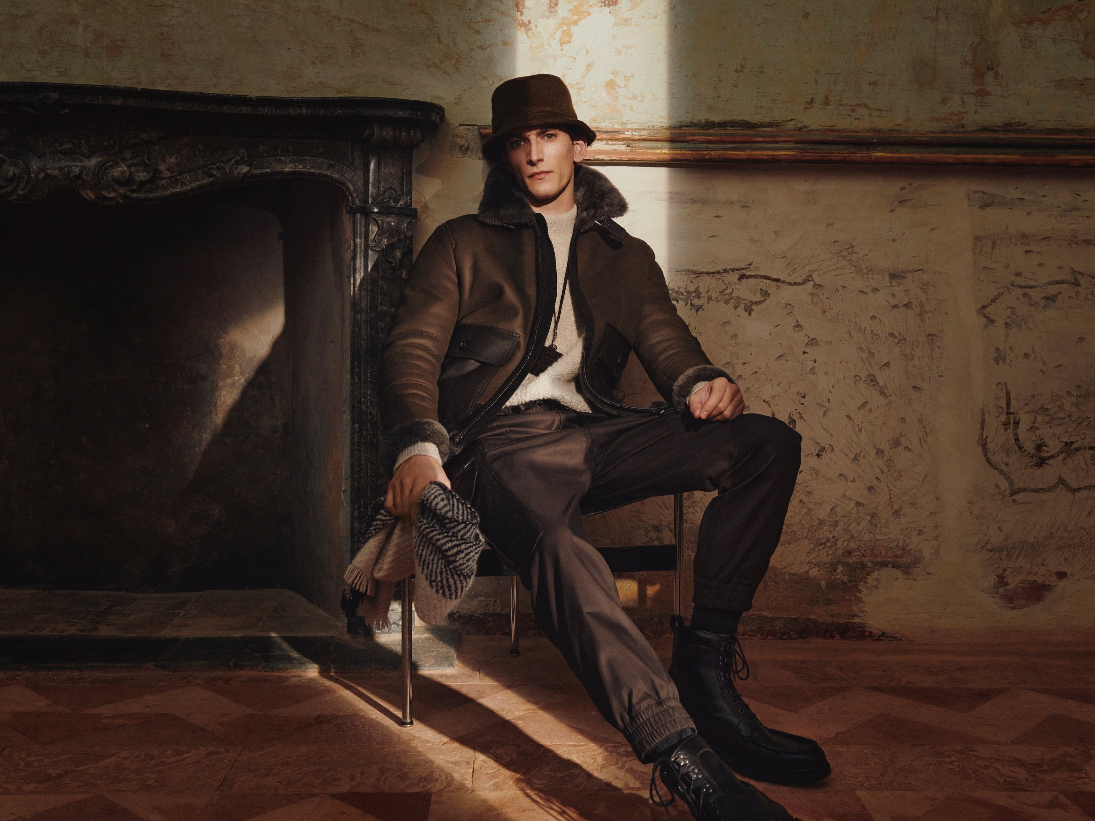 Brioni model wearing brown jacket, trousers and hat from the fall winter 22