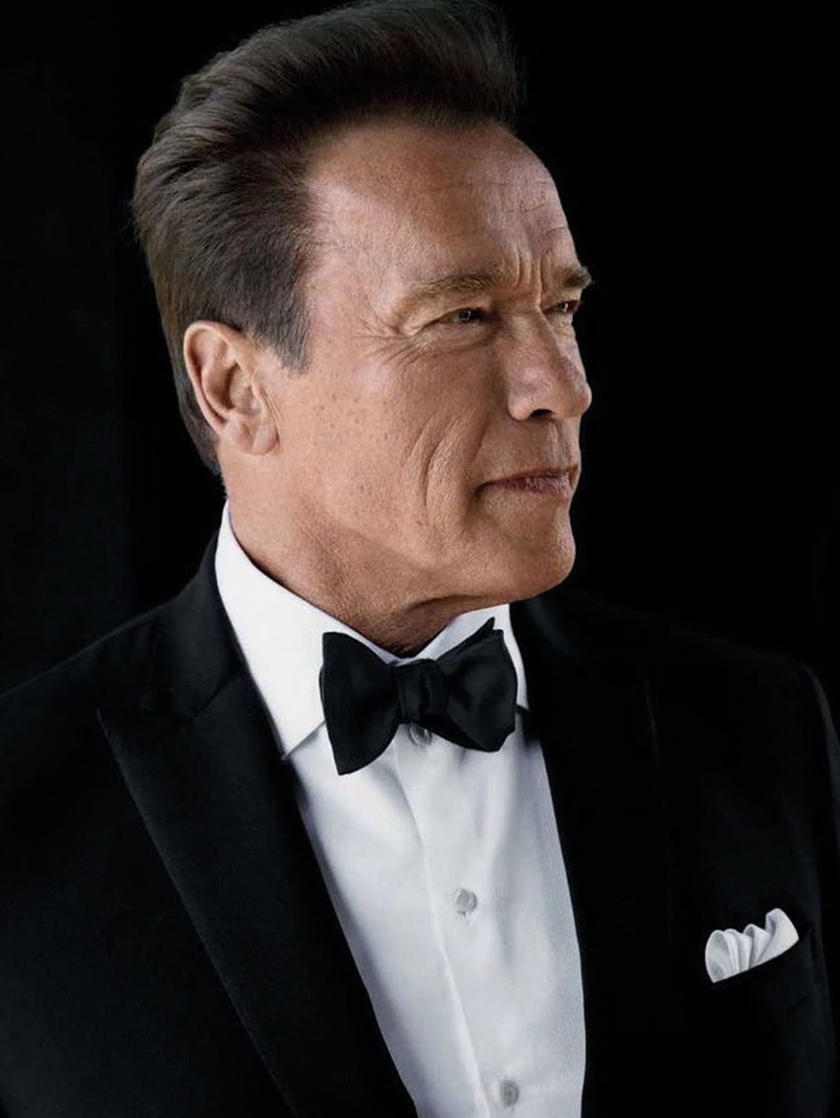 Arnold Schwarzenegger wearing a Brioni bespoke black tuxedo