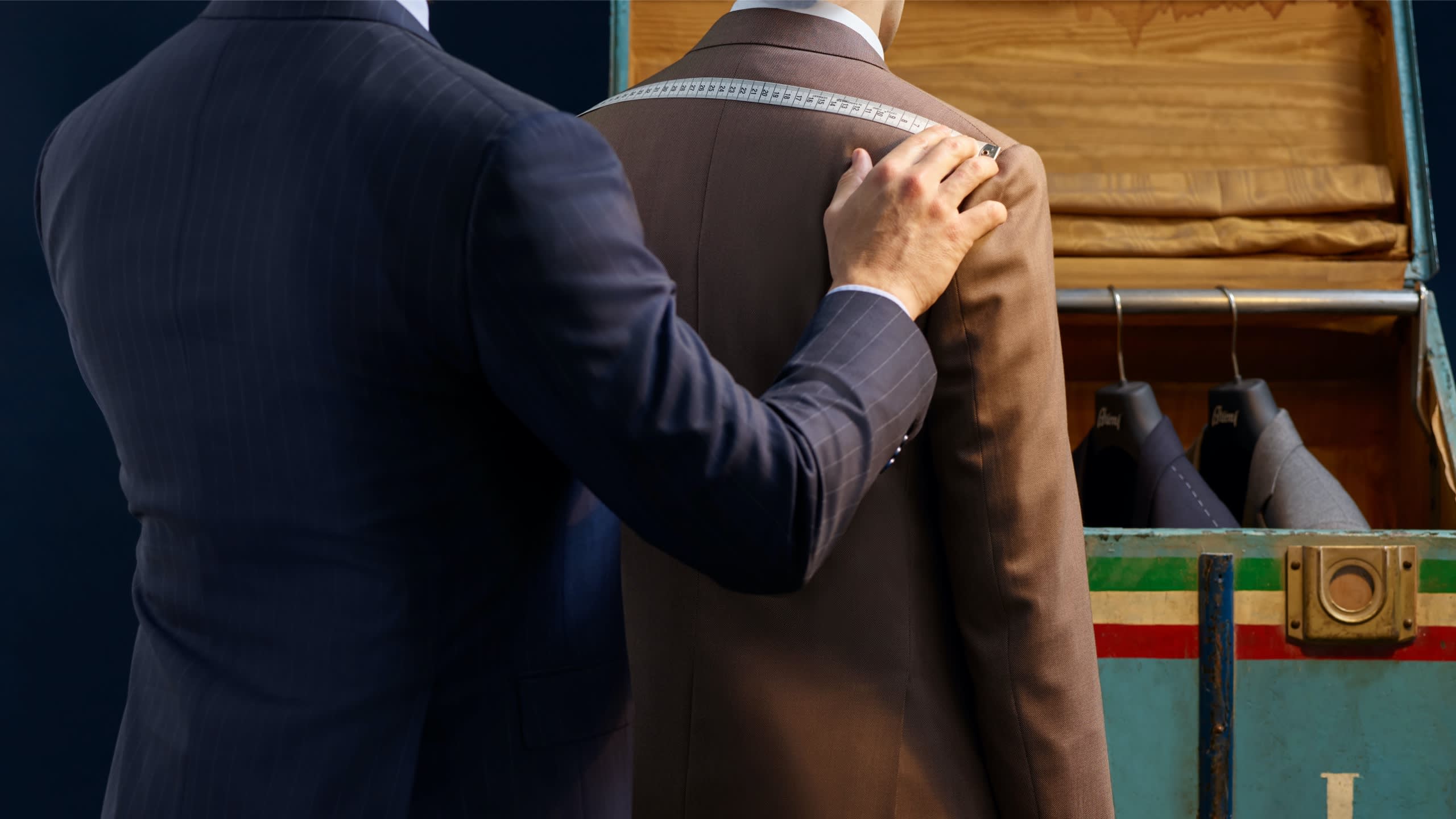 A Brioni master tailor taking the measurements of a client
