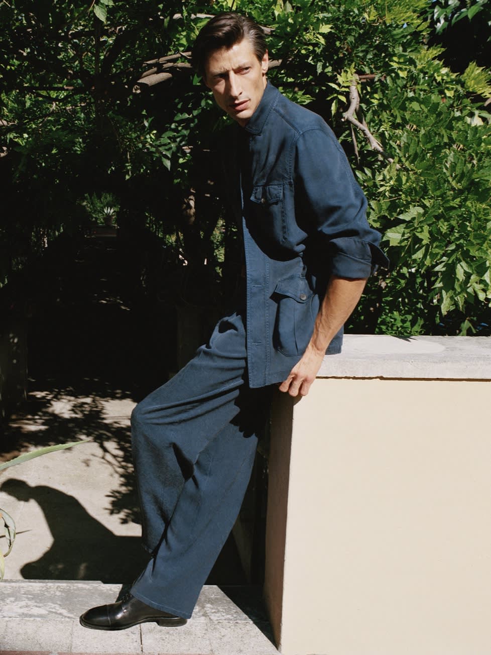 Male model wearing a navy blue washed silk sahariana and trousers