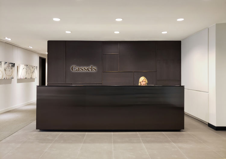 The reception desk is sculptural and monolithic made of dyed oak and statuary bronze