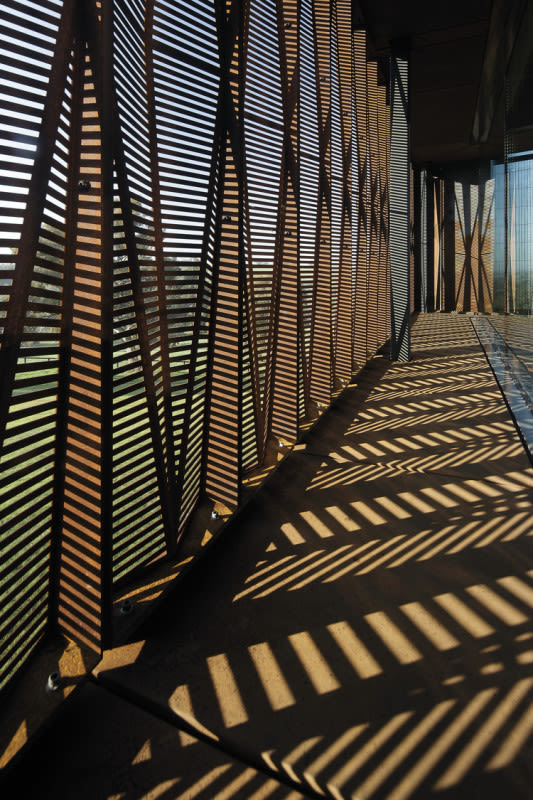 The artefact gallery extending along the south façade is protected from low sun by a weathered steel screen