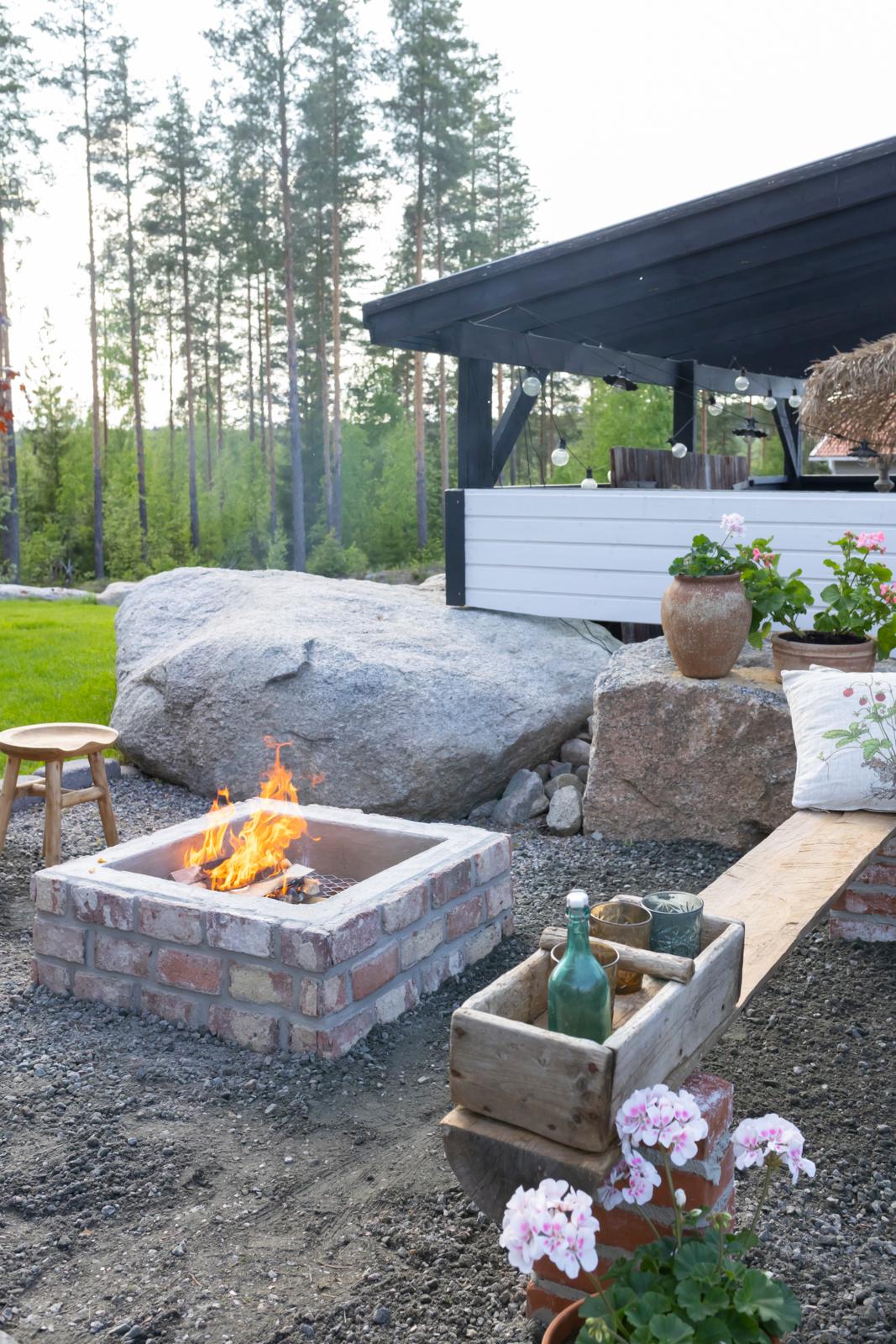 Kierrätysmateriaaleista rakennettu neliskanttinen tulipaikka
