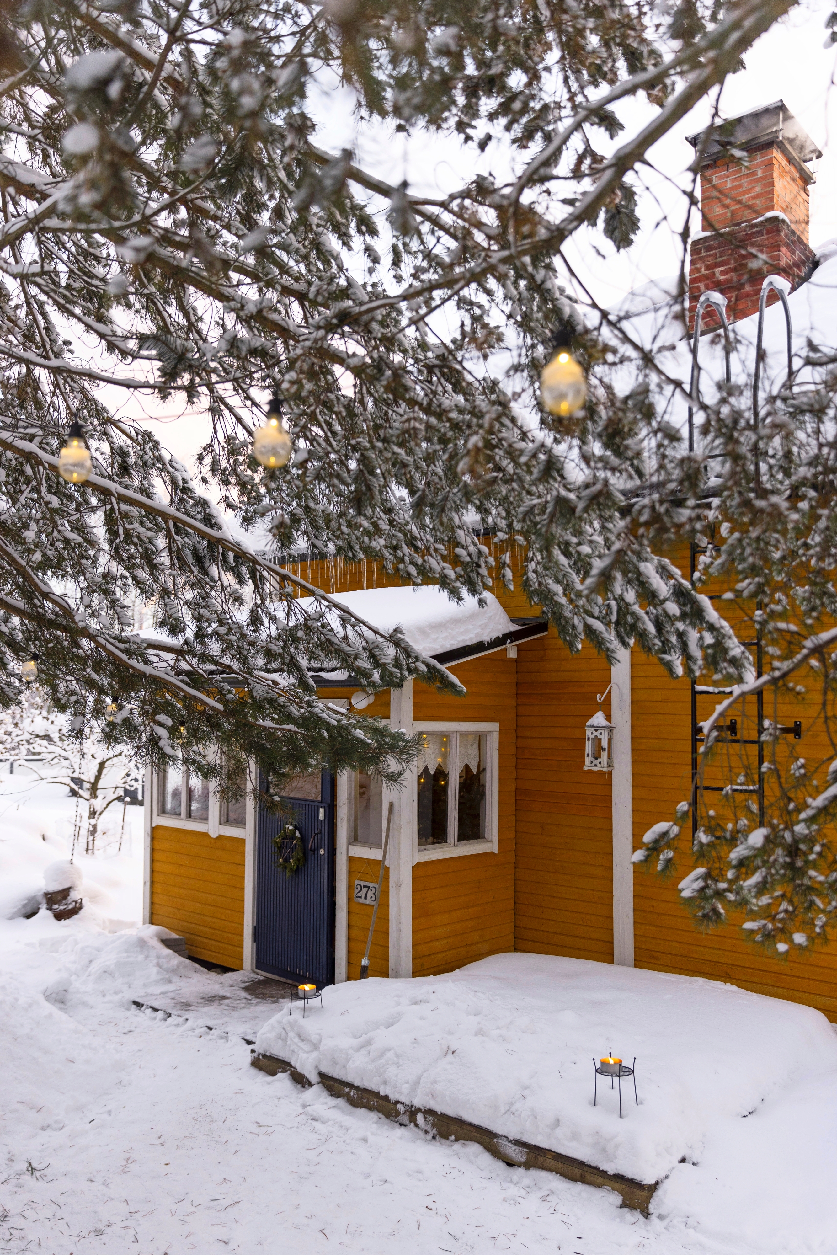 Keltainen puutalo lumimaisemassa