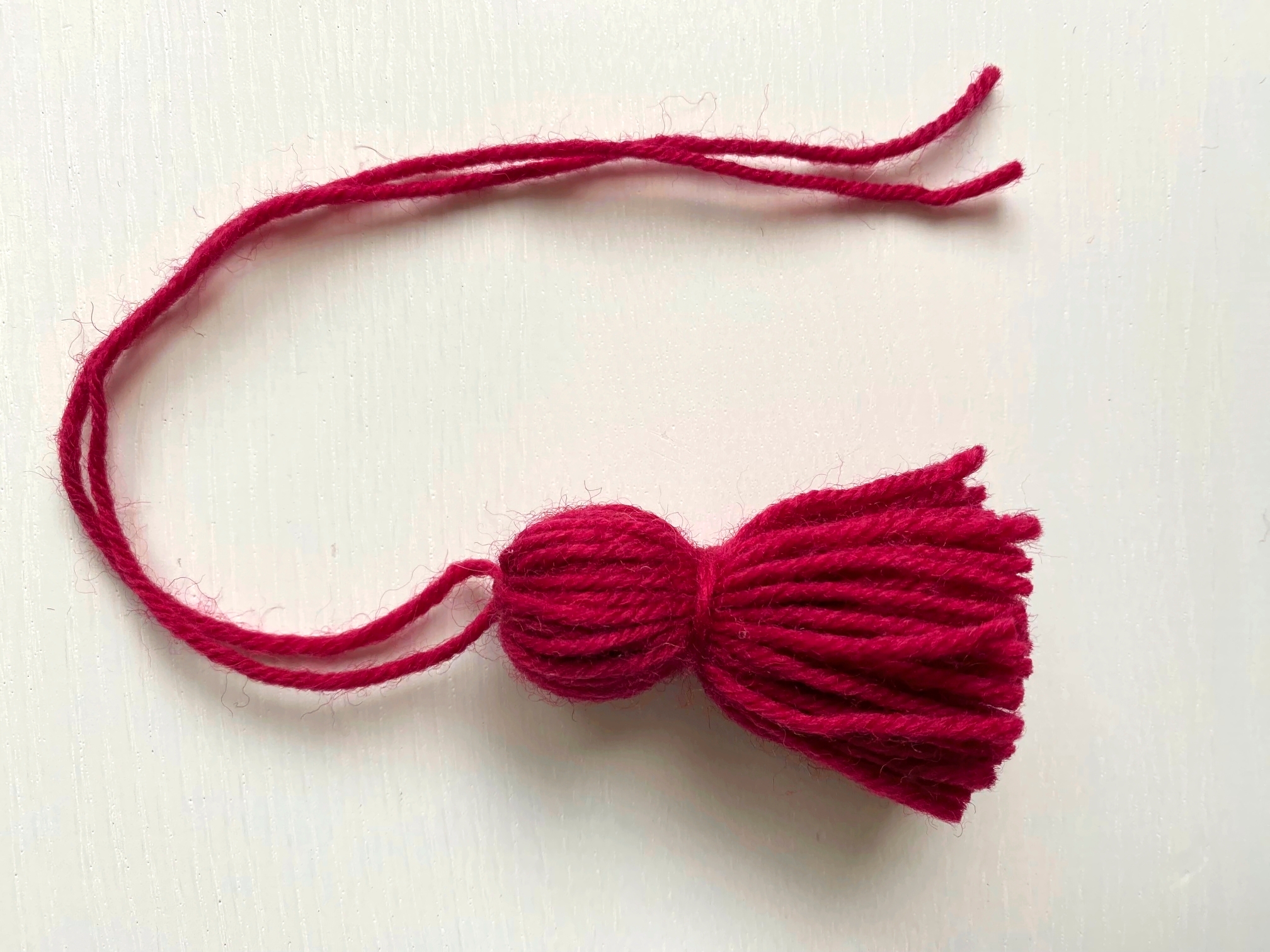 Solmi tasselit näin ja kiinnitä sukan yläreunaan.