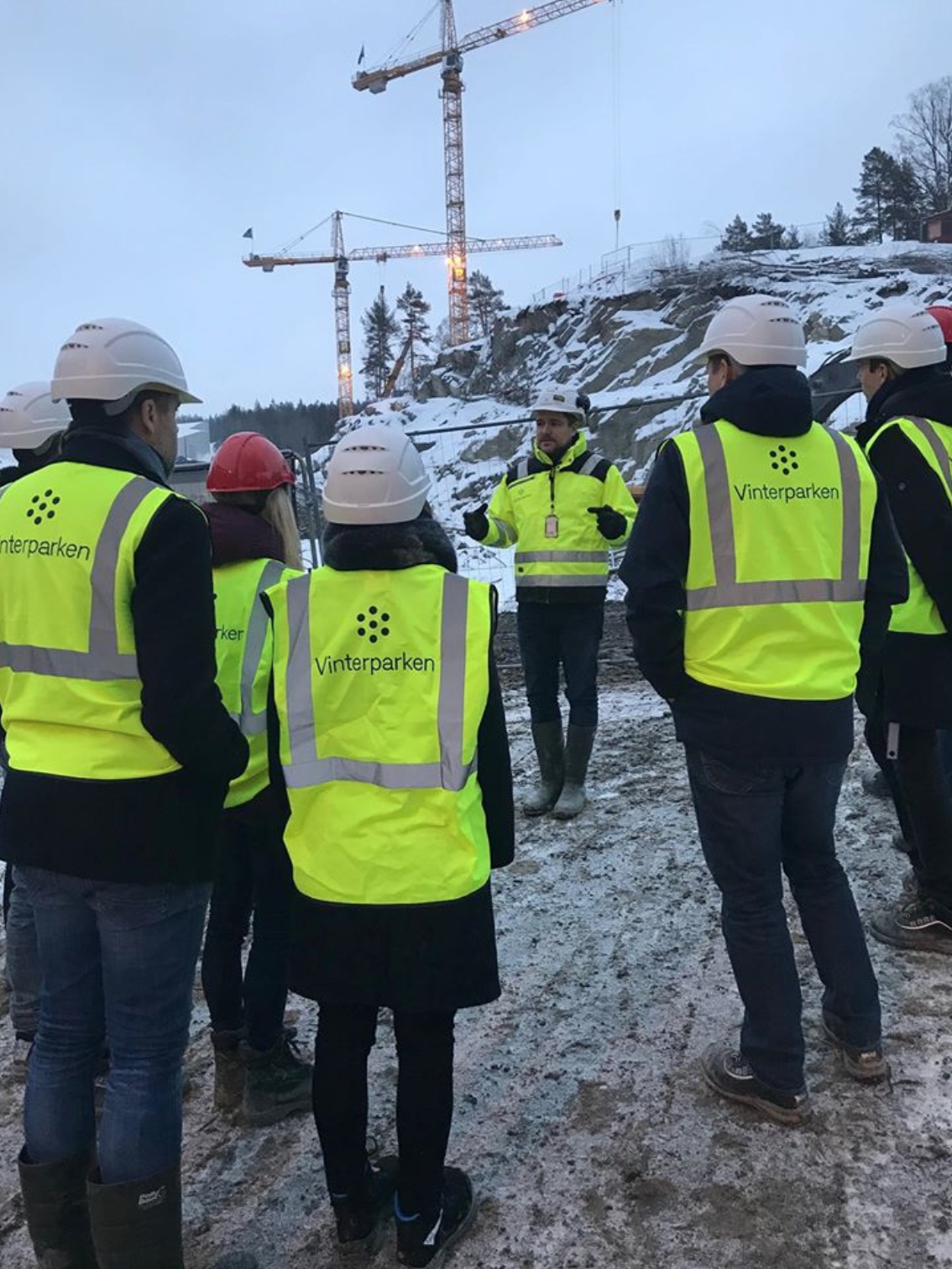 A team of people standing ouside looking at a building site