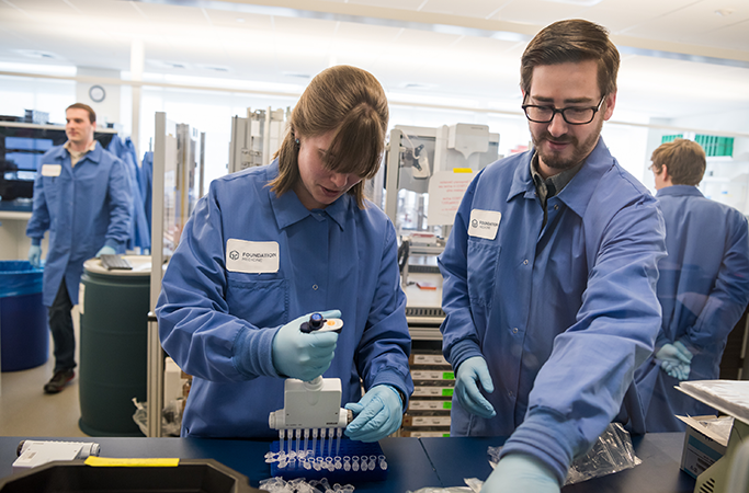 Foundation Medicine Employees Pipetting in a lab