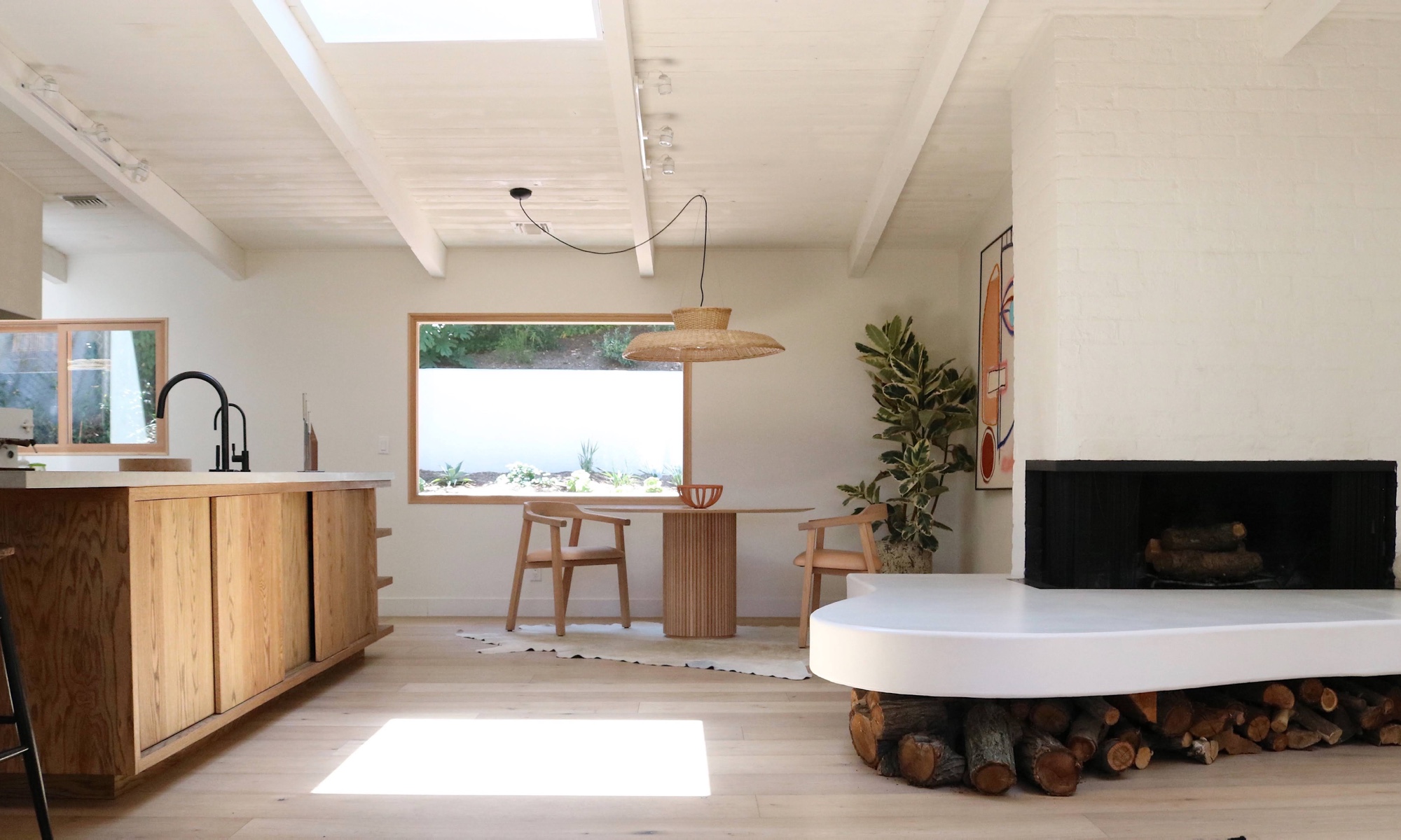 The family took the home down to the studs before adding in airy architectural elements like skylights and the curving hearth bench that also serves as wood storage.