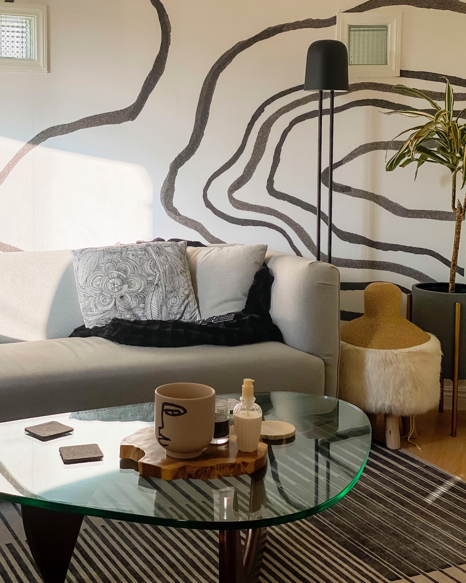 A sinuous wall mural adds an organic feel to modernist pieces (like a treasured Noguchi coffee table).