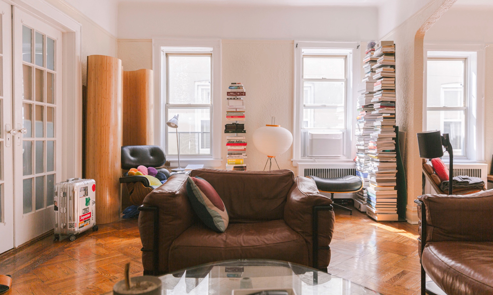 A Noguchi lamp illuminates a corner full of books.