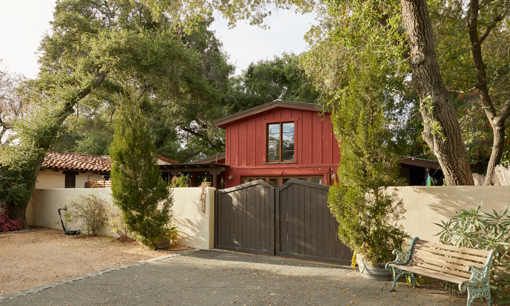 The house, built to resemble a barn, is situated among a grove of trees.