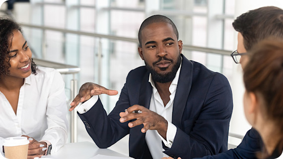 About Us Man leading corporate team during meeting