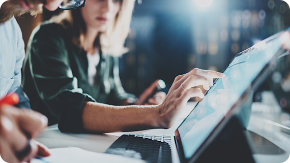 Woman pointing to a coworkers digital tablet.