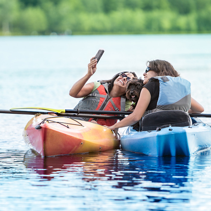 5G Hero Mother and daughter in kayaks taking video.