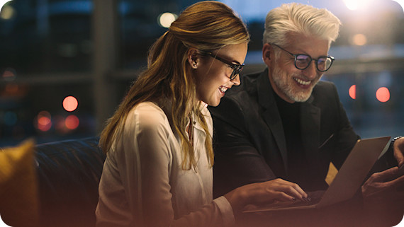 Two business professionals working late together in office.
