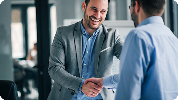 happy-men-handshake-office-870x490