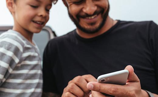 father-son-laughing-at-phone-870x490