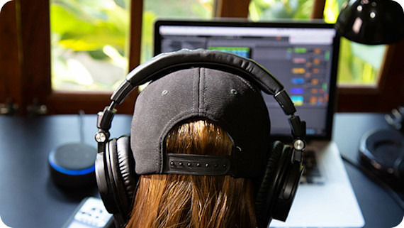 women wearing headphones watching laptopn screen