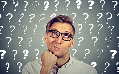 Man wearing glasses, with chin in hand on a question mark background