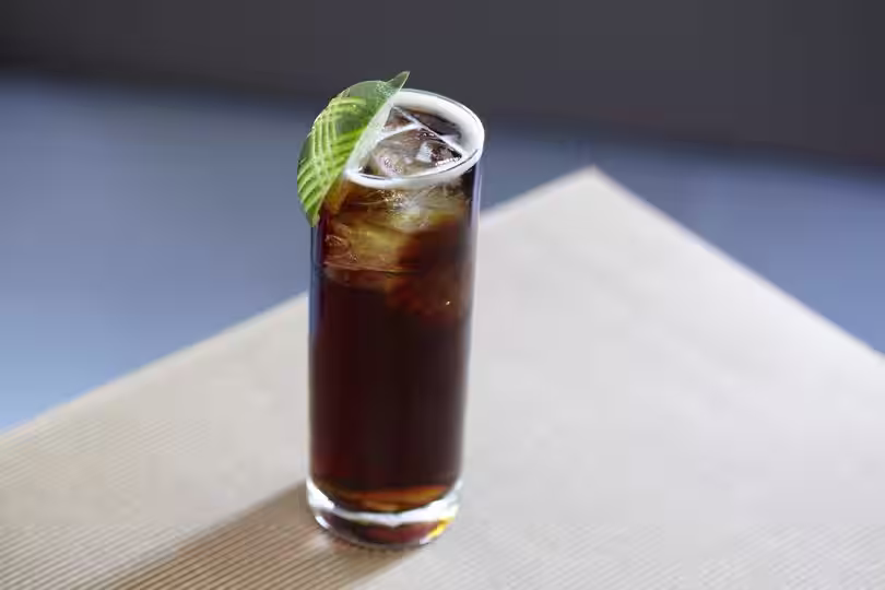 Enjoy a Crown Whisky and Cola with Crown Royal Deluxe Whisky, cola, and a slice of lime.