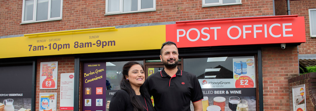 Image of two Postmasters standing in front of a Post Office branch Image of two Postmasters standing in front of a Post Office branch