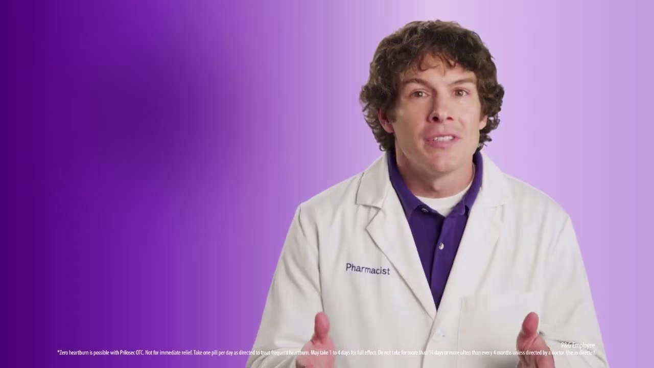 Person wearing a white lab coat with 'Pharmacist' embroidered on it, set against a purple gradient background includes Prilosec OTC disclaimer text about heartburn treatment duration and usage.