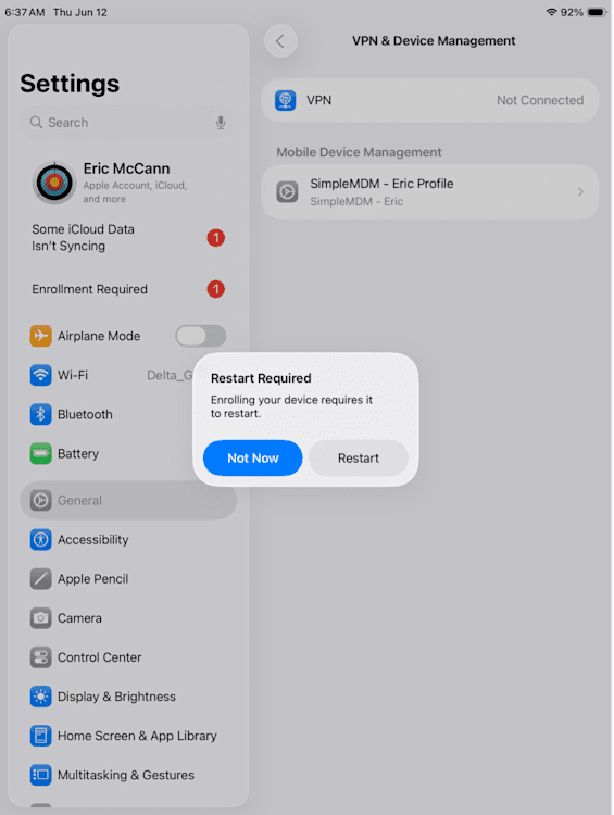 An iPad screenshot of the Settings app open to the “VPN & Device Management” section. A pop-up message titled “Restart Required” states, “Enrolling your device requires it to restart.” Below the message are two buttons: a blue “Not Now” button and a gray “Restart” button.