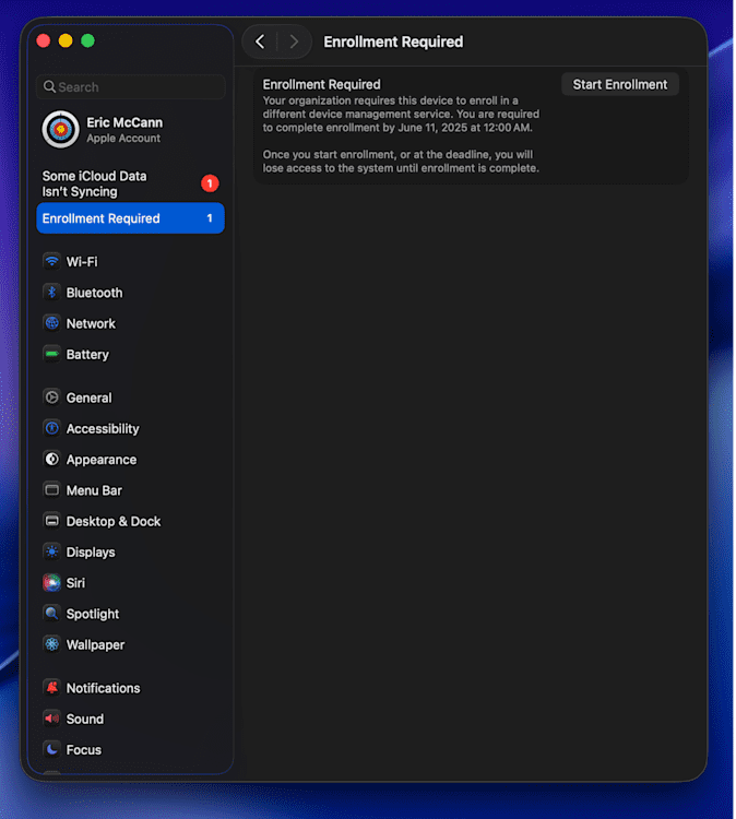 A macOS System Settings window showing the "Enrollment Required" section selected in the sidebar. The right pane displays a message stating that the organization requires the device to enroll in a different device management service by June 11, 2025 at 12:00 AM. A button labeled "Start Enrollment" appears on the top right of the message. The left sidebar also shows a red badge for a syncing issue under "Some iCloud Data Isn't Syncing," and various system categories like Wi-Fi, Bluetooth, Battery, Accessibility, and others.