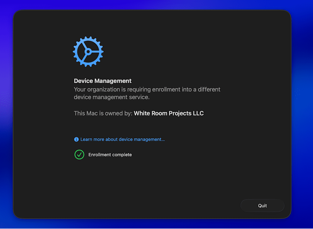 A macOS dialog box titled "Device Management" with a blue gear icon at the top. The message states that the organization requires enrollment into a different device management service and that the Mac is owned by "White Room Projects LLC." A green checkmark icon appears with the message “Enrollment complete.” A blue link below the text reads “Learn more about device management…” and there is a “Quit” button in the bottom-right corner.